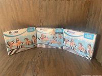 Three boxed Aqua 4-in-1 Monterey Hammock inflatable pool lounger units standing side-by-side on wood floor.