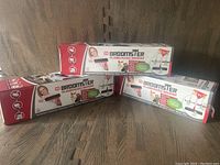 Three boxed Broomster Rubberized Brooms stacked with visible brand and packaging details.