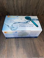 Box front showing product name, image of the showerhead, and water splash graphic.