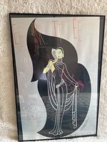 Full view of framed Erte foil print featuring stylized female figure and red text.