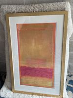 Full view of the framed gold and pink abstract rectangular print displaying the overall artwork and frame condition.