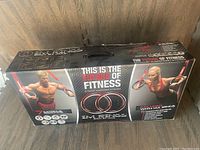 Box front showing product name, fitness purpose, images of users, and highlight of dynamic suspension system.