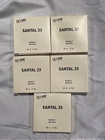 Five boxed bars of Le Labo Santal 33 soap arranged flat.