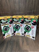 Photo showing three boxed Lizard Cam Micro-Inspection Cameras arranged side by side with clear product branding and features visible on the package.