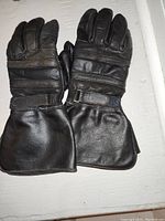 Top view of the black leather motorcycle gloves showing knuckle protection, adjustable wrist straps, and gauntlet cuffs.