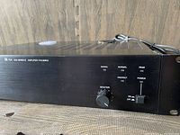 Front angle view of TOA P-912mk2 amplifier showing power switch, master volume knob, and status LEDs on black metal casing.