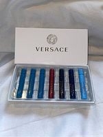White Versace branded box holding five colored sample vials, each vial approximately half full or more.