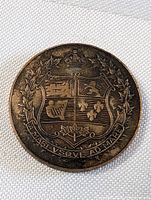 Front face of the coin medallion showing detailed Canada coat of arms with maple leaf wreath and inscription