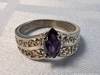 Front view of the sterling silver ring with a marquise-cut amethyst and detailed filigree band.