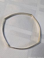 Top view of the sterling silver geometric bracelet showing overall shape and smooth surface.