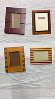 Four assorted wooden picture frames laid out showing front and design details.