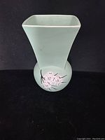 Front view of green McCoy vintage vase showing floral artwork on rounded base and square top opening.