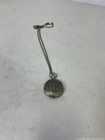 Full view of the bronze pocket watch with chain laid flat, showing embossed Platform 9 3/4 Kings Cross London on front cover.