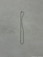 Full view of the sterling silver chain laid flat to show entire length and slender profile.