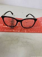 Front view of Kate Spade Jalisha eyeglasses frame in black floral tortoiseshell pattern on orange bubble wrap.