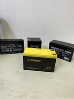 Four rechargeable batteries of various brands and specifications, arranged on a flat surface.