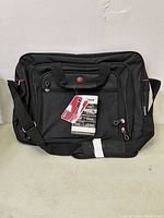 Front view of black Swiss Gear laptop/business bag showing zippered compartments, carry handles, shoulder strap and logo