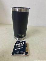 Front view of Yeti Rambler cup with Yeti logo visible and care/use cards.
