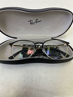Ray-Ban eyeglasses inside black hard case with white interior and logo on the lid
