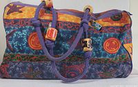 Full view of colorful patterned large canvas beach bag with purple handles and decorative beads.