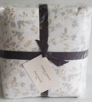 Flannel sheet set folded and wrapped with a brown ribbon, showing floral pattern and tag.