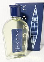 Photo of the Canoe after shave bottle with label and cap in front of the box showing brand and design