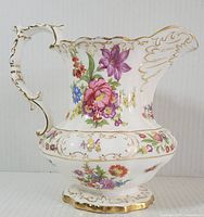Full side view of bone china pitcher showing floral sprays and gold trim