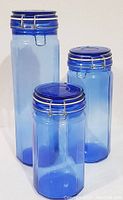 Photo showing the set of three graduated cobalt blue glass canisters with wire bail lids arranged from tallest to shortest.