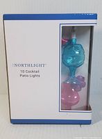 Photo of boxed Northlight 10 cocktail patio lights showing product name and some light shapes through clear window.