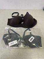 Photo showing two American Eagle bras, one brown laid out and the other grey in plastic bag, both size 36B