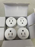 Open box showing four white Gosund smart plugs arranged inside.