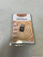 Photo of the first sealed dual band USB WiFi adapter package showing the front view with specifications and adapter inside plastic blister pack.