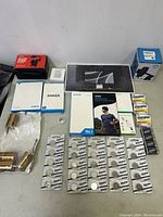 Top down view showing multiple battery packs including Energizer 2025 coin cells and AA batteries, plus Samsung wireless charger and Anker accessories in unopened boxes.