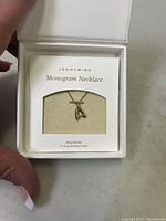 Jenny Bird Gold-Plated Letter A Monogram Necklace displayed in branded white box with interior cushioning, showing pendant and chain.