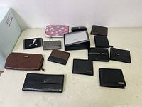 Overview of 13 wallets on a flat surface showing size and color variety