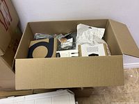 Box containing various electronics and cables in packaging