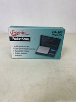 Boxed Genie CS-100 pocket scale with product details on front.
