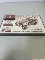 Box front showing the product as a scale model vehicle from the 1940s, Army Field Car, 1:18 scale, with text about no glue and self-assembly.