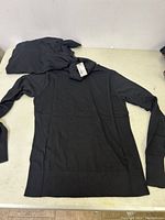 Two black men's turtleneck sweaters shown flat, one fully visible, the other folded showing neck tag.