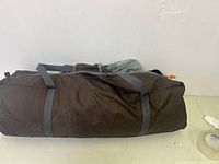 Side view of brown carry bag storing tent canopy and components