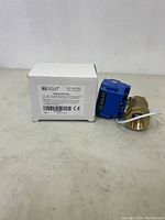 Motorized ball valve alongside its white retail box with brand and specifications visible.