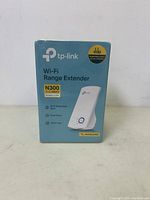 Front view of sealed TP-Link Wi-Fi Range Extender N300 packaging showing device image and key features