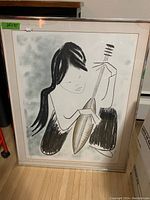 Front view of the framed print showing the stylized figure playing an instrument, with black, gray and white tones