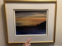 Frontal view of the oil painting showing the vibrant sunset scene and framing.