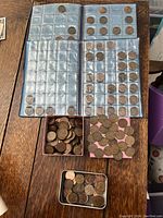 Four coin albums filled with pennies mainly Canadian with some US pennies, some empty slots also present