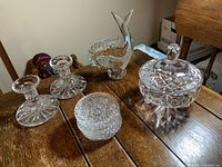 Overview of all items on a wooden table including fish figurine, candy bowl, candlesticks, and coasters.