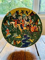 Front view of handpainted Kutahye Turkish bowl showing detailed Ottoman Empire themed design with figures on horseback, animals, and landscape in rich colors.