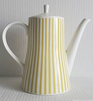 Side view of ceramic tea pot showing yellow vertical stripe pattern on white background with curved handle and spout.