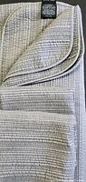 Folded taupe grey duvet cover showing textured grid and stripe quilting with binding detail and fabric label.