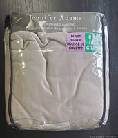 Jennifer Adams 3 piece duvet cover set packaged, showing folded fabric with product label indicating king size, duvet cover set, and brand name.